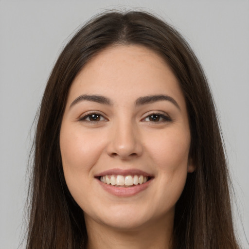 Joyful white young-adult female with long  brown hair and brown eyes