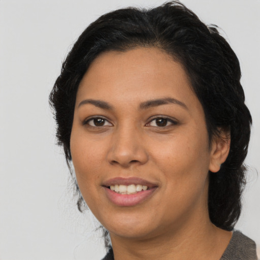 Joyful latino young-adult female with medium  black hair and brown eyes