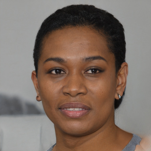 Joyful black young-adult female with short  black hair and brown eyes