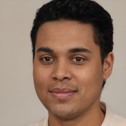 Joyful latino young-adult male with short  black hair and brown eyes