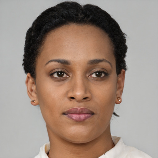 Joyful black young-adult female with short  brown hair and brown eyes