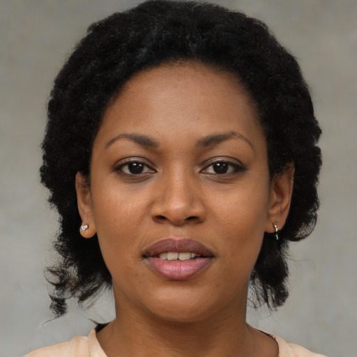 Joyful black young-adult female with medium  black hair and brown eyes