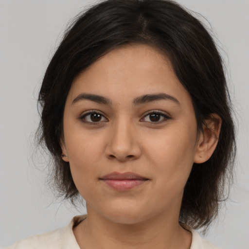 Joyful latino young-adult female with medium  brown hair and brown eyes