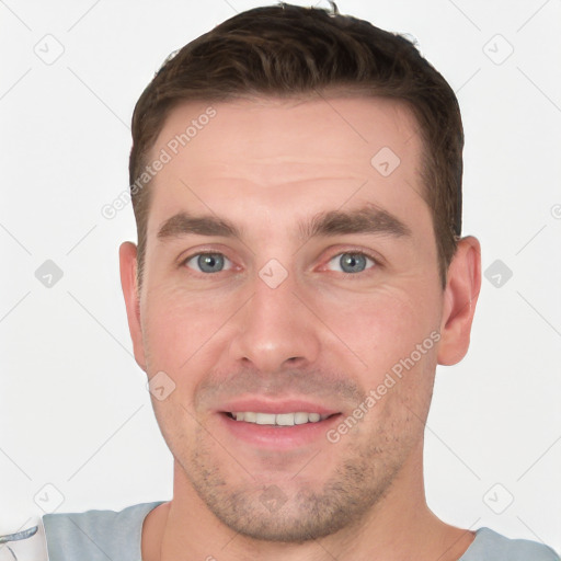 Joyful white young-adult male with short  brown hair and grey eyes