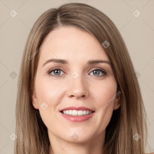 Joyful white young-adult female with long  brown hair and grey eyes