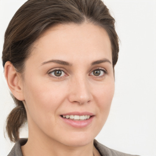 Joyful white young-adult female with medium  brown hair and grey eyes