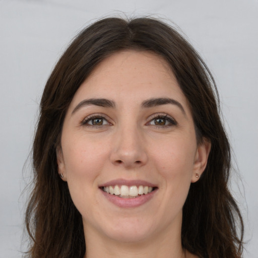 Joyful white young-adult female with long  brown hair and brown eyes