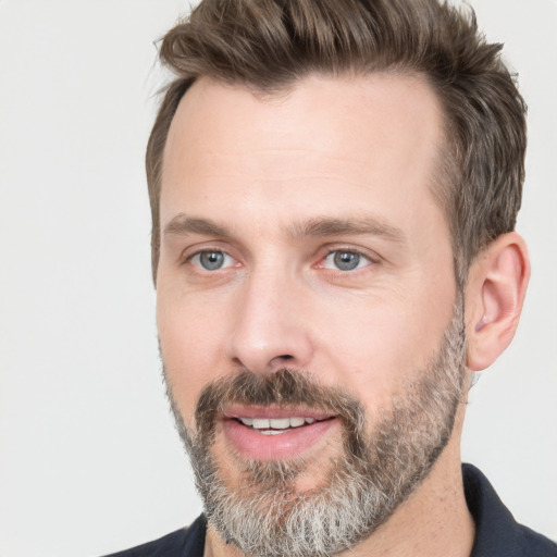 Joyful white adult male with short  brown hair and grey eyes