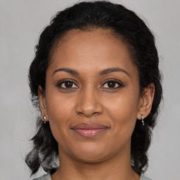 Joyful black adult female with medium  brown hair and brown eyes