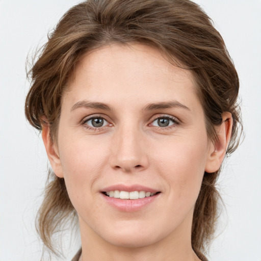 Joyful white young-adult female with medium  brown hair and grey eyes