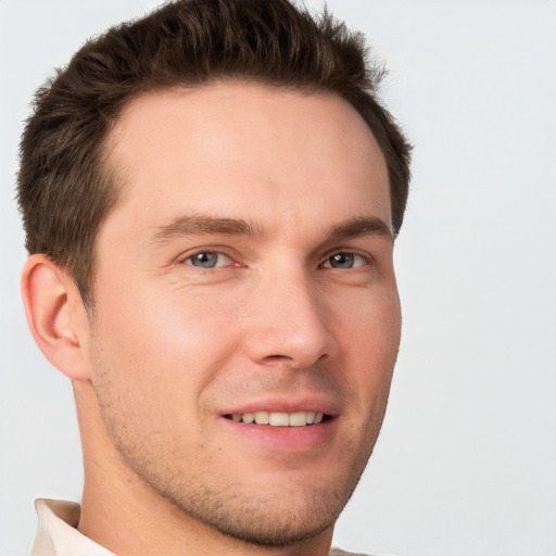 Joyful white young-adult male with short  brown hair and grey eyes