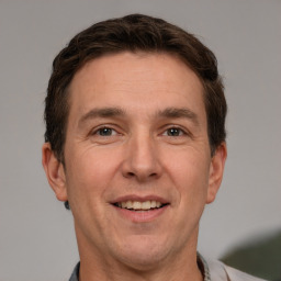 Joyful white adult male with short  brown hair and grey eyes