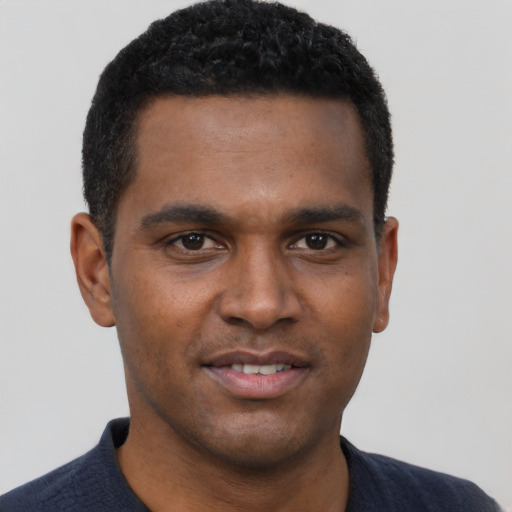Joyful black young-adult male with short  black hair and brown eyes