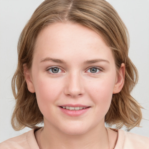 Joyful white young-adult female with medium  brown hair and blue eyes