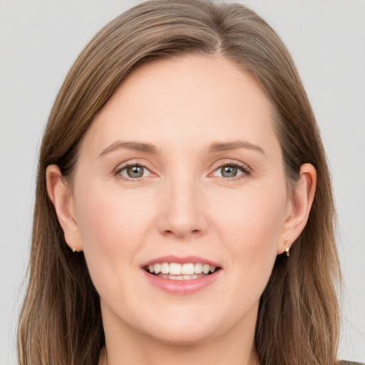 Joyful white young-adult female with long  brown hair and grey eyes