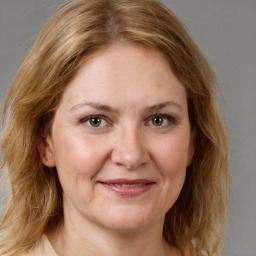 Joyful white adult female with medium  brown hair and green eyes