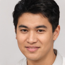 Joyful asian young-adult male with short  brown hair and brown eyes