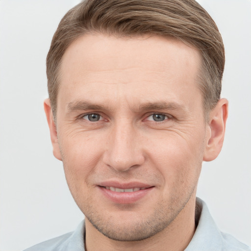 Joyful white adult male with short  brown hair and grey eyes