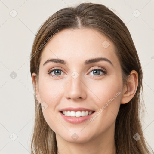 Joyful white young-adult female with long  brown hair and grey eyes