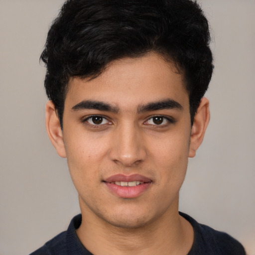 Joyful latino young-adult male with short  black hair and brown eyes