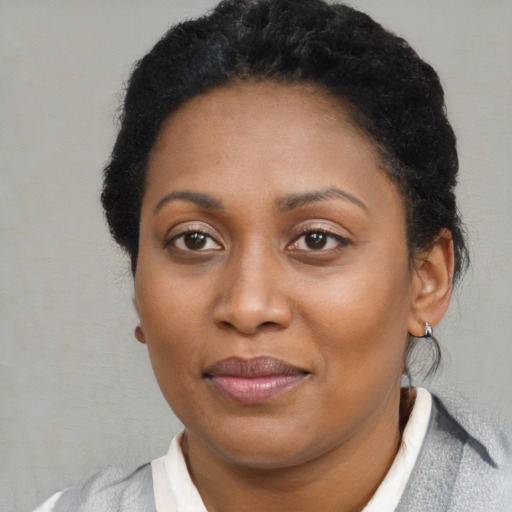 Joyful black young-adult female with short  brown hair and brown eyes
