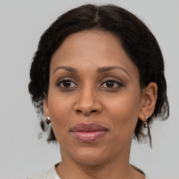 Joyful black adult female with medium  brown hair and brown eyes