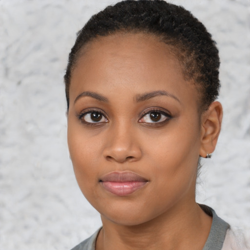 Joyful black young-adult female with short  brown hair and brown eyes
