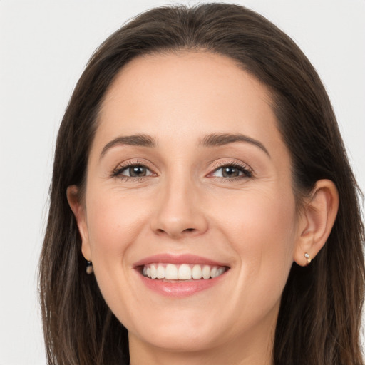 Joyful white young-adult female with long  brown hair and brown eyes