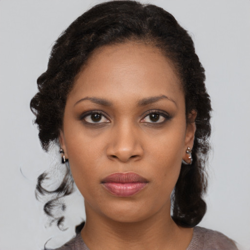 Joyful black young-adult female with medium  black hair and brown eyes