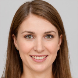 Joyful white young-adult female with long  brown hair and green eyes