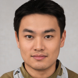 Joyful asian young-adult male with short  black hair and brown eyes