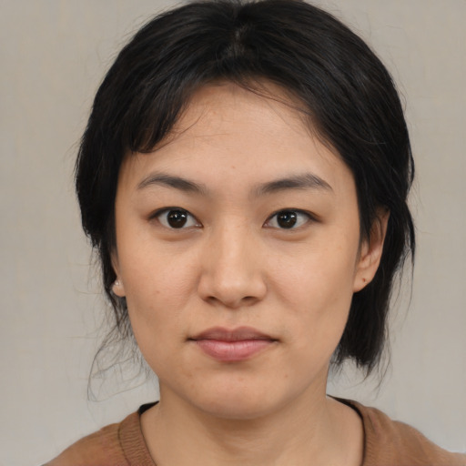 Joyful asian young-adult female with medium  black hair and brown eyes