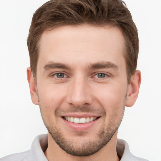 Joyful white young-adult male with short  brown hair and grey eyes