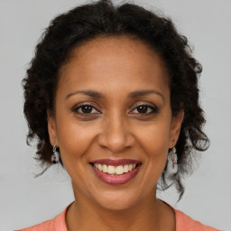 Joyful black adult female with medium  brown hair and brown eyes