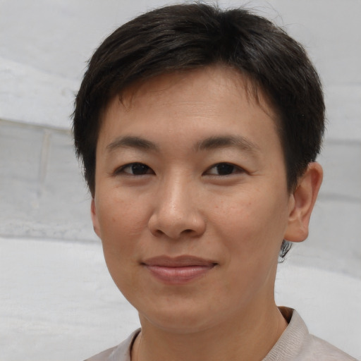 Joyful asian young-adult female with short  brown hair and brown eyes