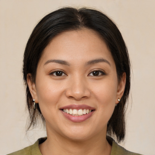 Joyful latino young-adult female with medium  brown hair and brown eyes