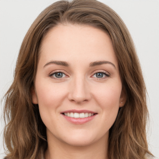 Joyful white young-adult female with long  brown hair and green eyes