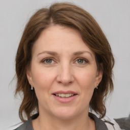 Joyful white adult female with medium  brown hair and grey eyes