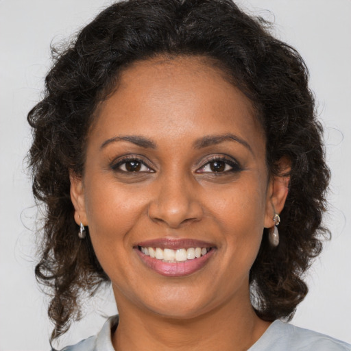 Joyful black young-adult female with medium  brown hair and brown eyes