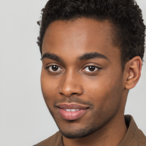 Joyful black young-adult male with short  brown hair and brown eyes