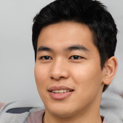 Joyful asian young-adult male with short  black hair and brown eyes
