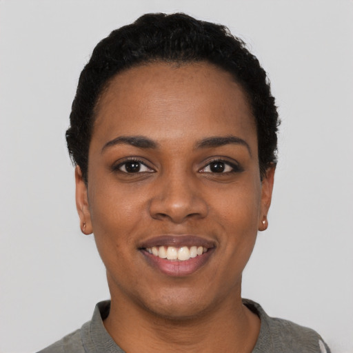 Joyful black young-adult female with short  black hair and brown eyes