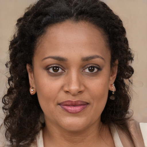 Joyful black young-adult female with long  brown hair and brown eyes