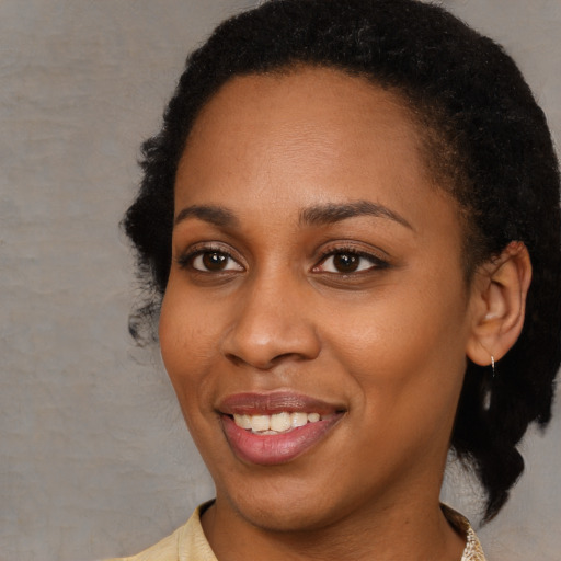 Joyful black young-adult female with short  brown hair and brown eyes