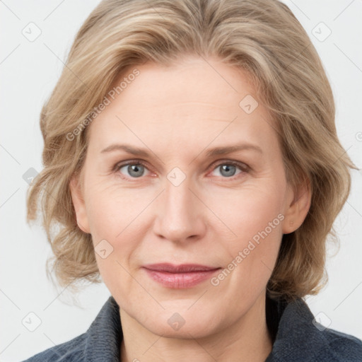 Joyful white adult female with medium  brown hair and blue eyes