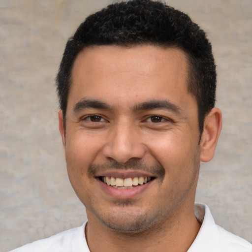 Joyful white young-adult male with short  black hair and brown eyes