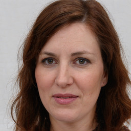 Joyful white adult female with long  brown hair and brown eyes