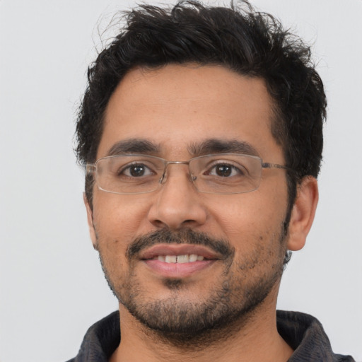 Joyful latino adult male with short  black hair and brown eyes