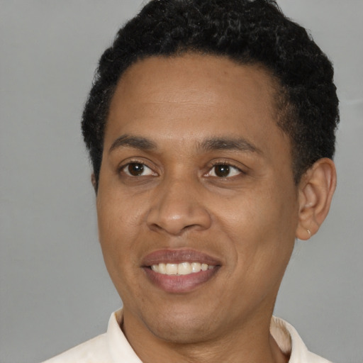 Joyful black young-adult male with short  black hair and brown eyes