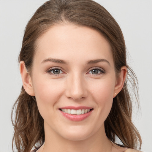 Joyful white young-adult female with medium  brown hair and grey eyes